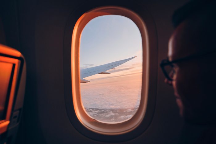 Man looking throught vindow of airplane
