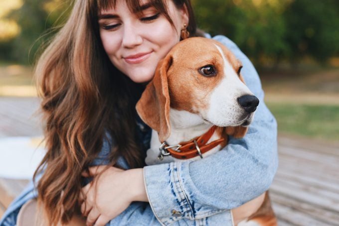 young girl hugging her beagle dog
