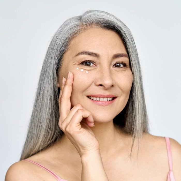 Happy middle aged mature asian woman headshot portrait. Skin care, eye care ads