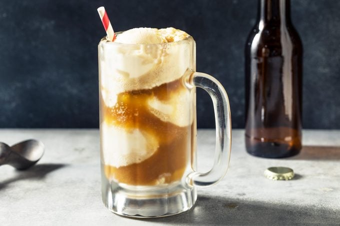 rootbeer float in a glass mug with a paper straw