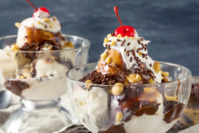 classic hot fudge tin roof sundae in a dish with whip cream cherries and nuts
