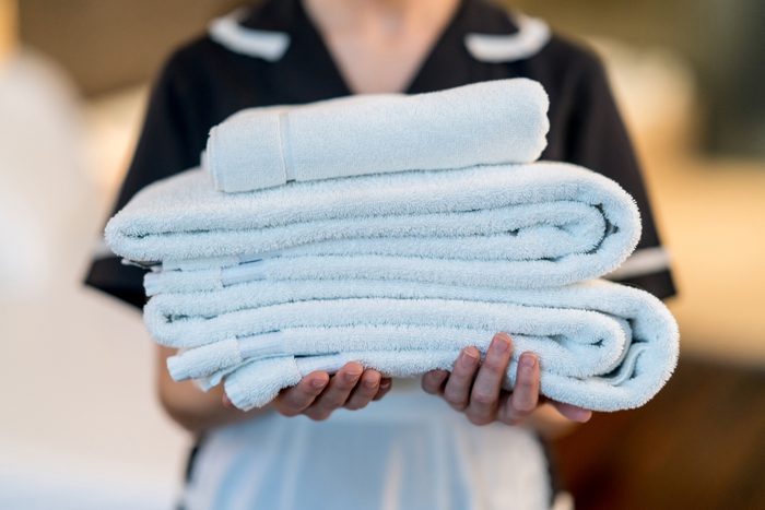 Unrecognizable housekeeper holding towels at a hotel