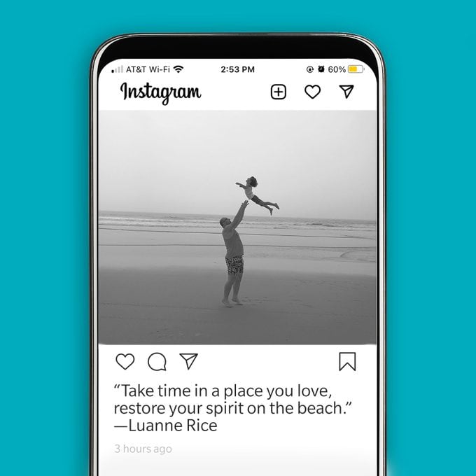 instagram mock up on a phone with a black and white image of a man and small child with an inspirational beach quote as the caption