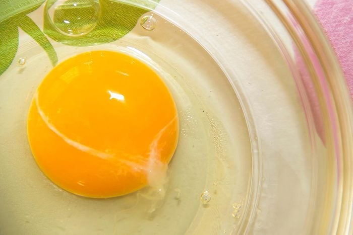 raw egg in a clear bowl close up