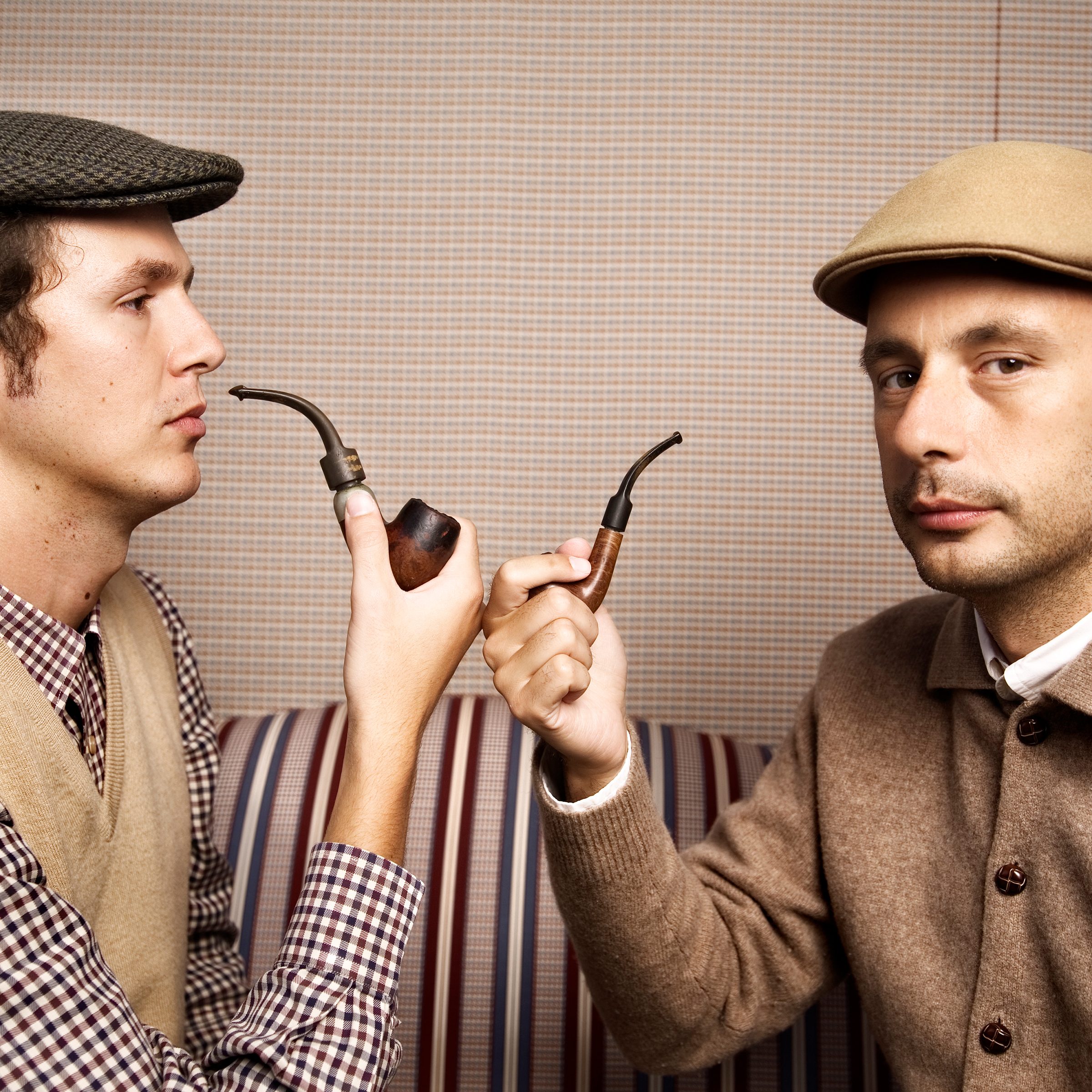 Two Men Wearing Newsboy Caps and Smoking Pipes