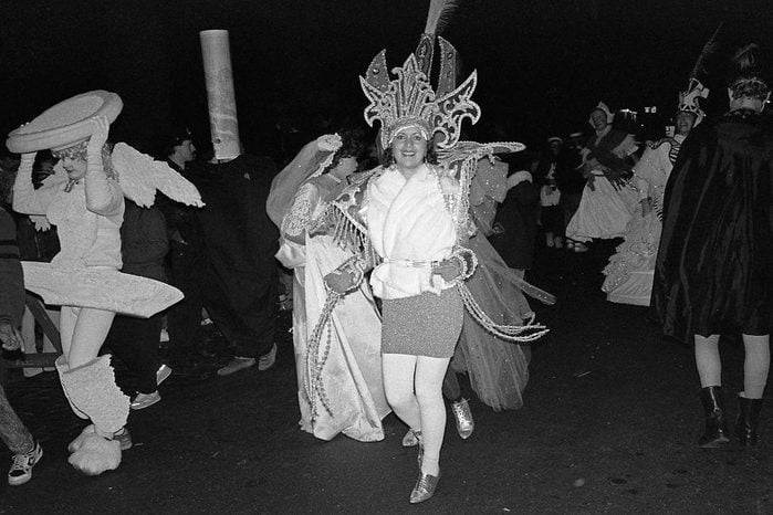 View of a woman in a Carnival costume, as she smiles and dances along 6th Avenue during New York's annual Village Halloween Parade, New York, New York, October 31, 1988.