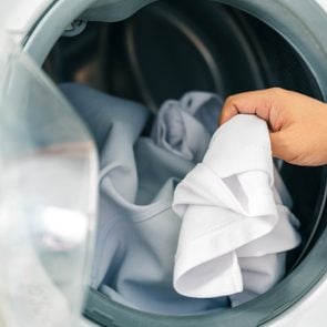 person removing shrunken clothes from the dryer