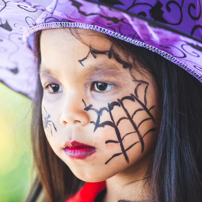 little girl with witch halloween face paint