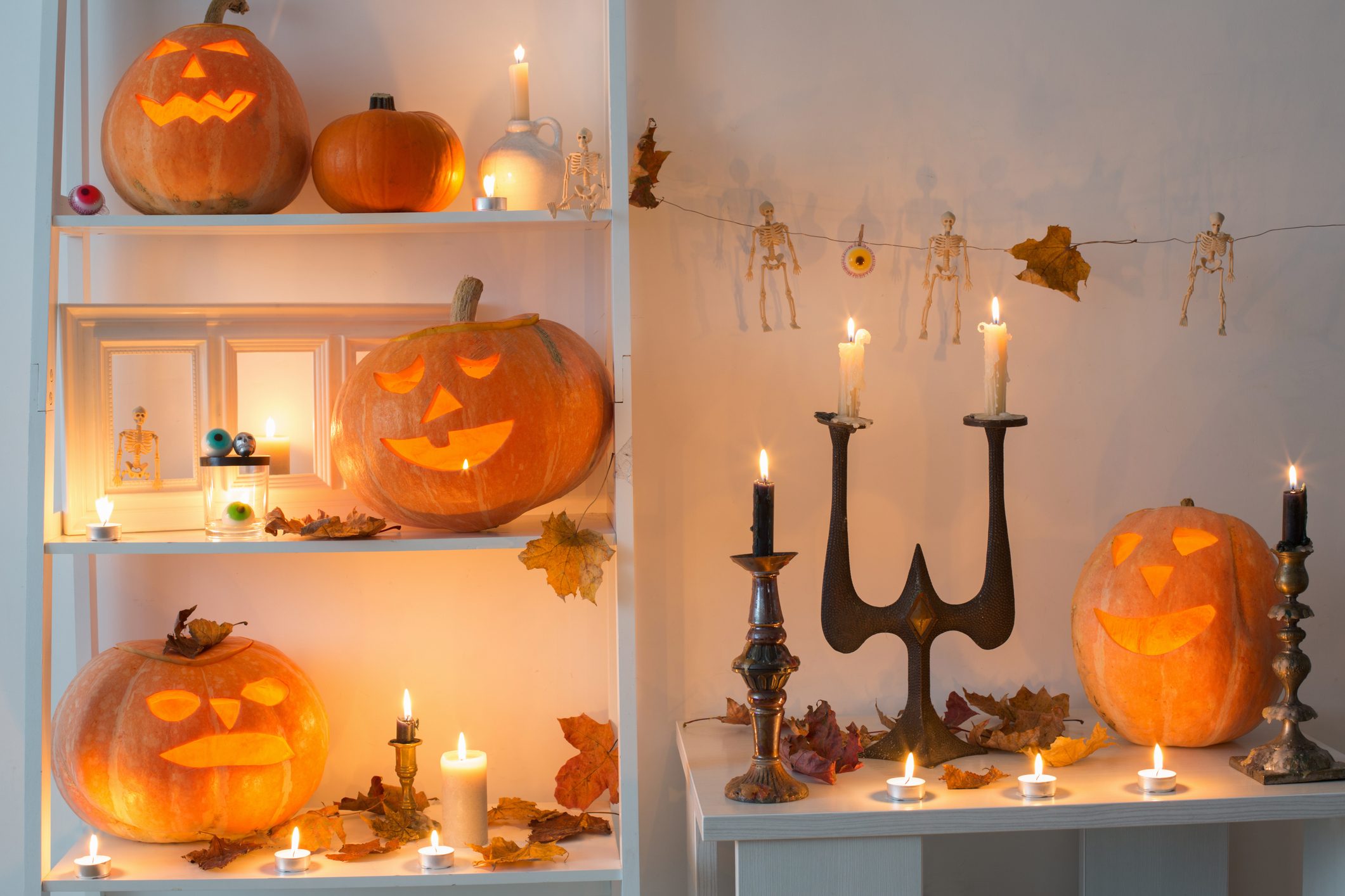 halloween pumpkins with candles and candlesticks and other halloween decor on wooden table