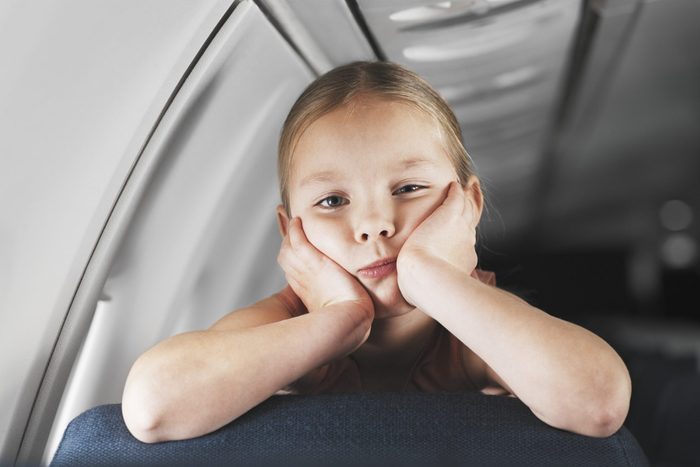 Girl touching her face on an airplane
