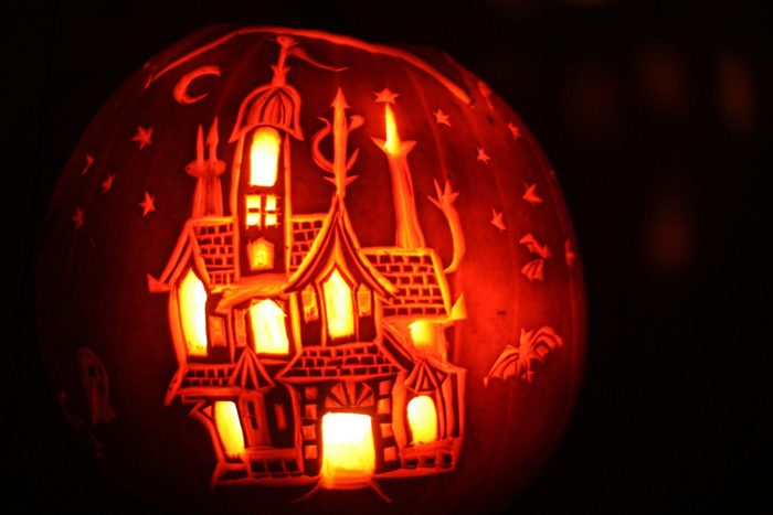 Carved pumpkin with haunted house