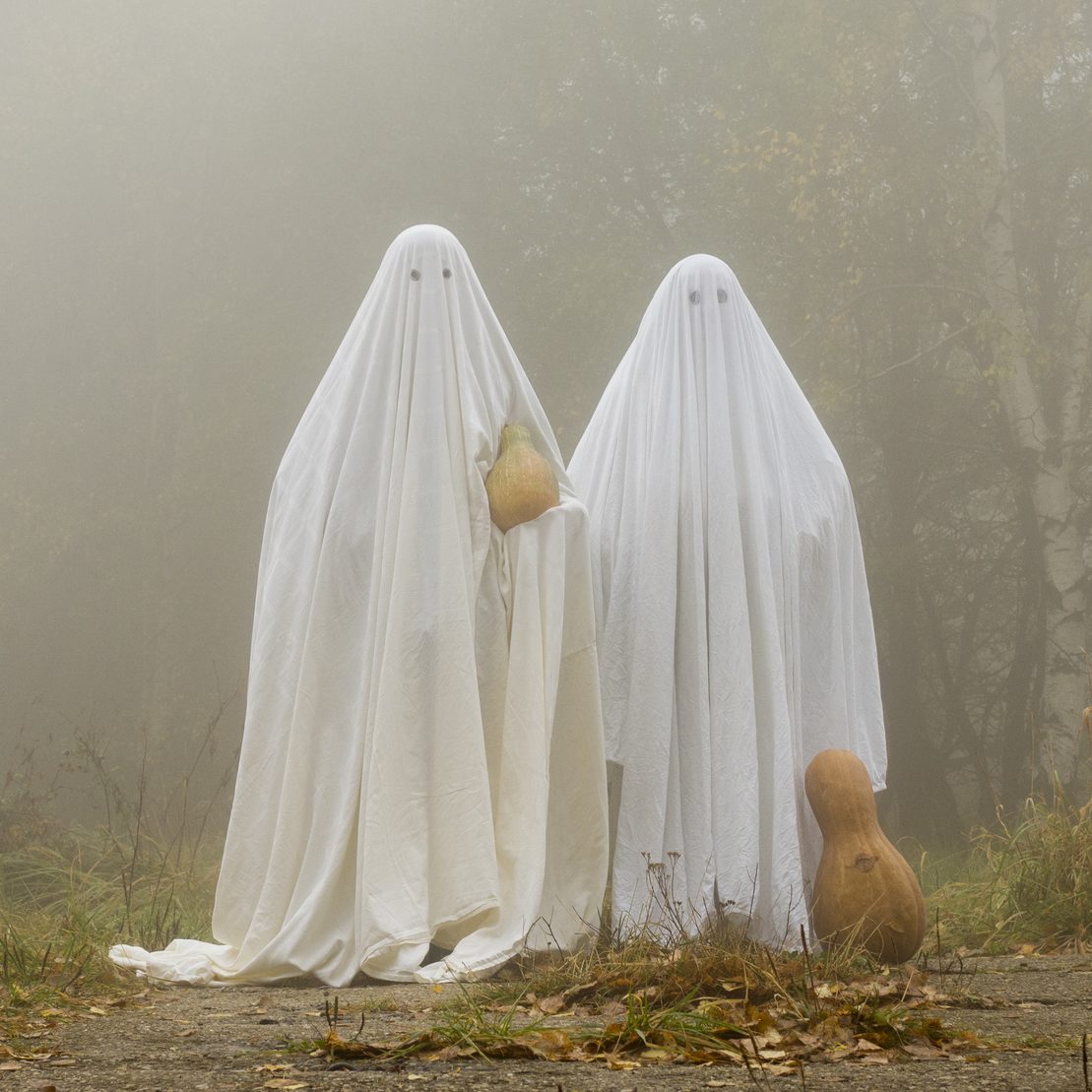 Two scary ghost halloween costumes in the woods