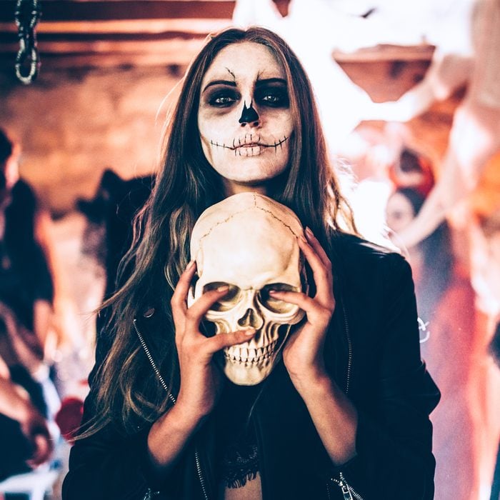 Gettyimages 916493964 Young Woman With Skeleton Make Up Holding Skull At Halloween Party Credits Wundervisuals