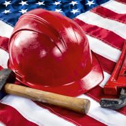 Hard hat, hammer, and wrench on an American flag