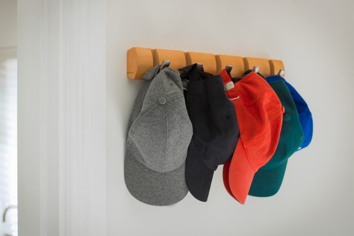 baseball hats hanging on hooks in home