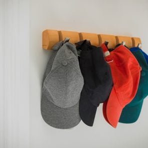 baseball hats hanging on hooks in home