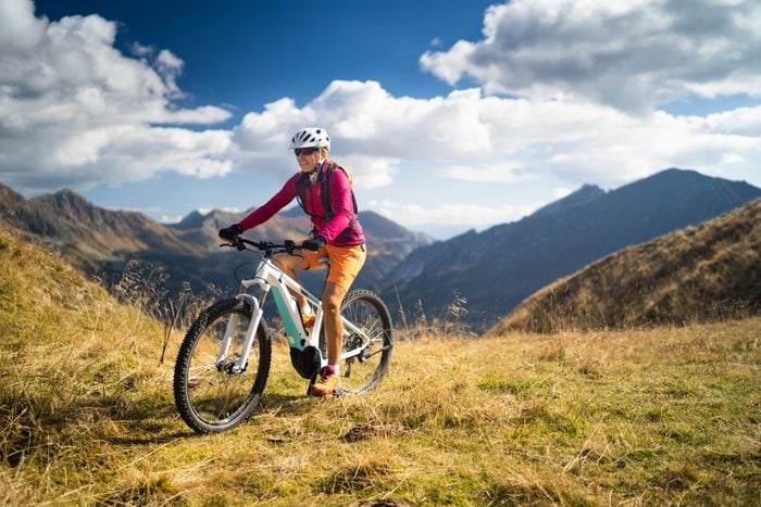 woman riding her bike through the mountains