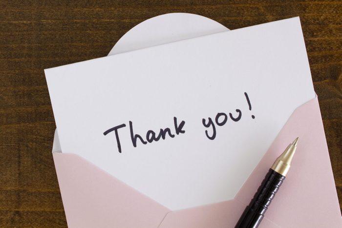 written Thank you card with pen on wood table