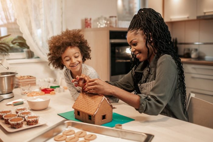 Mother And Her Daughter Assembling Gingerbread House