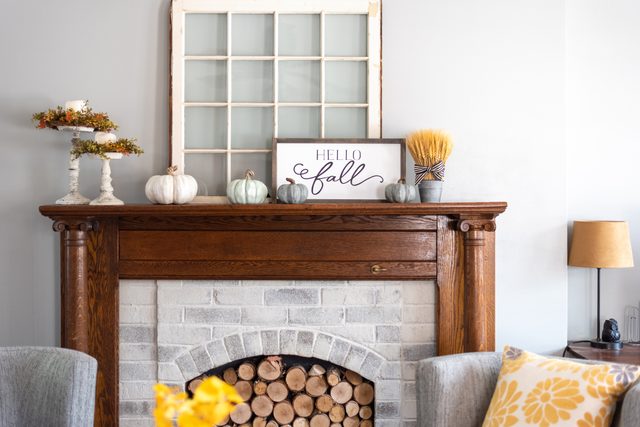 Stylish fall home decorations on a mantel in a living room