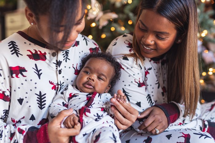 three sisters wearing matching christmas pajamas