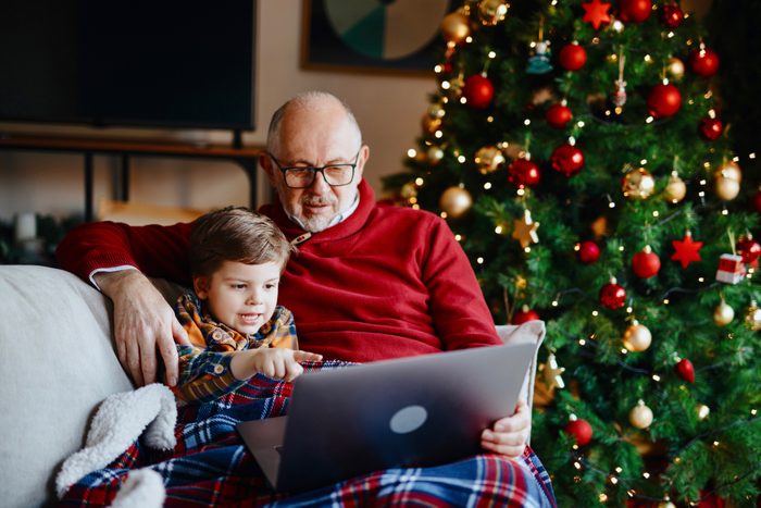 grandfather and grandson following santa tracker on computer on christmas eve