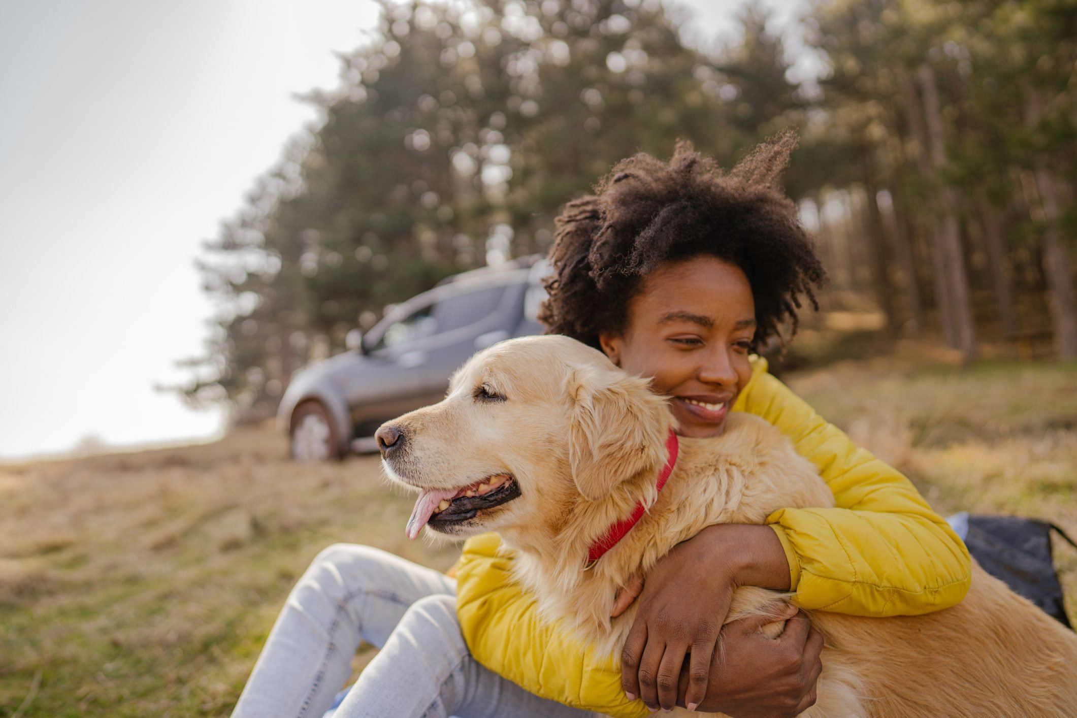 young woman hugging her golden retriever dog