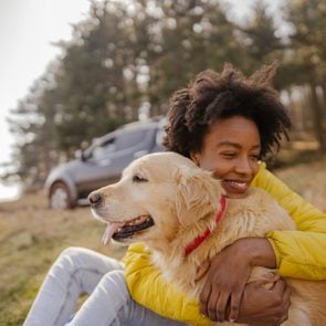young woman hugging her golden retriever dog