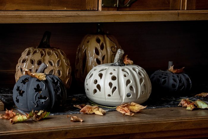 ceramic halloween pumpkins on wood shelf