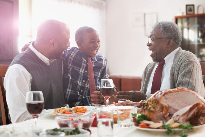 family laughing and talking at thanksgiving dinner