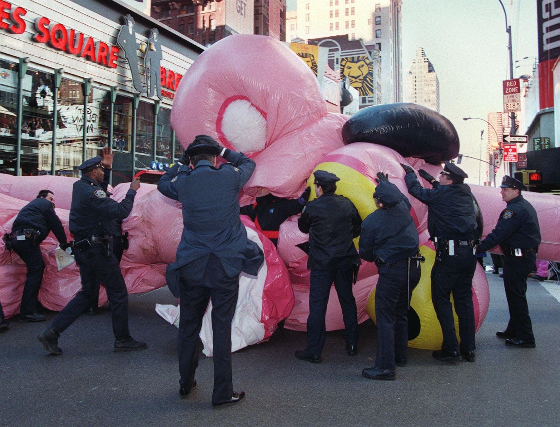 New York City Police rush to the aid of the Pink Panther balloon as it collapses after being blown over due to high winds 27 November at the 71st annual Macy's Thanksgiving day parade in New York.