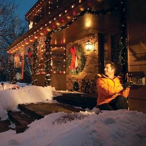 man plugging in christmas lights in outdoor outlet