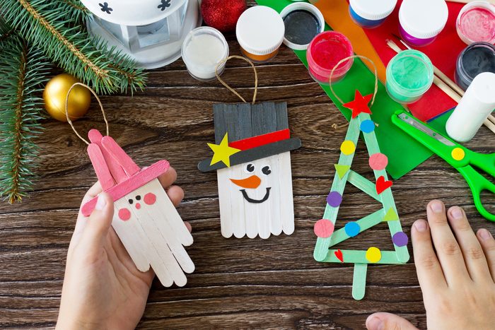 A child is holding Christmas decoration or Christmas gift wooden sticks