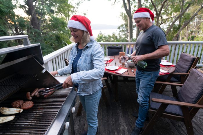 couple in santa hats having a christmas barbecue