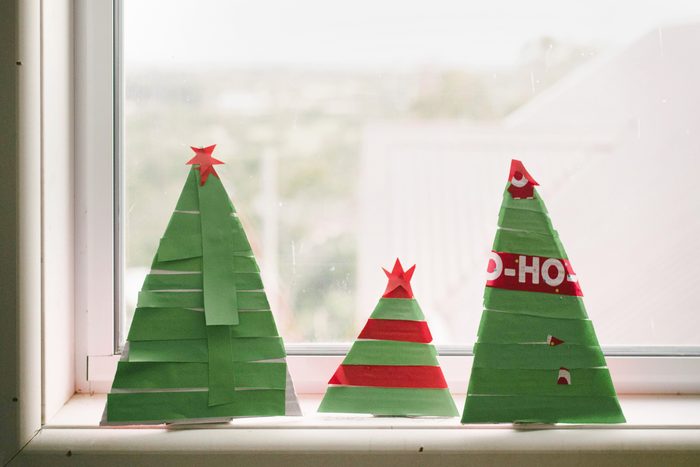 Close-up of paper Christmas trees on window sill at home