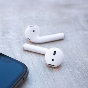 apple air pods and i iphone laying on a wood background