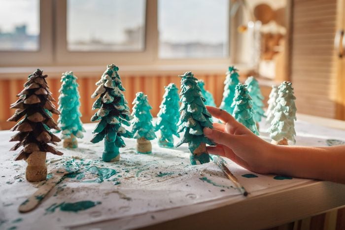 girl coloring in green a cone as if it is small toy pine tree, natural materials and handmade presents, zero waste holidays