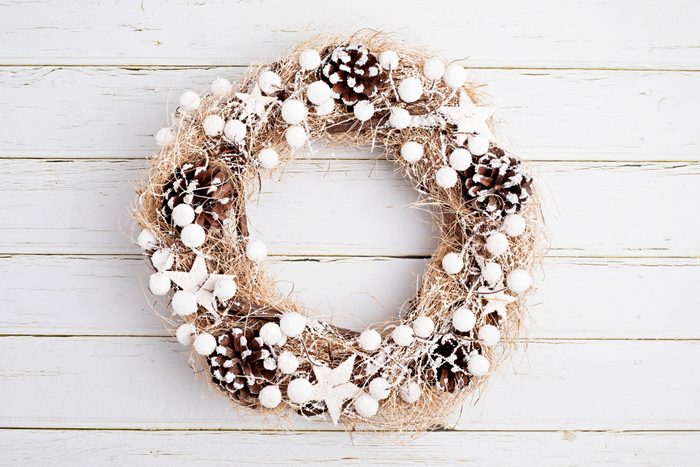 Top view of traditional Christmas wreath with copy space over neutral wooden background