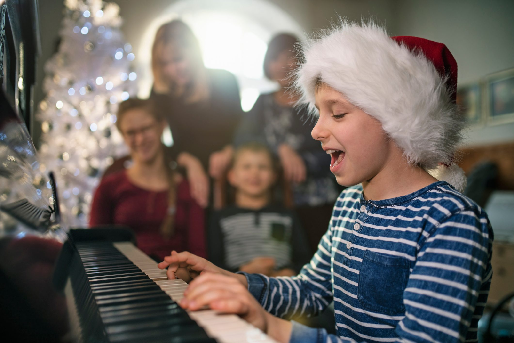 Little boy playing and singing carols on Christmas