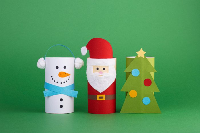 Handmade Christmas toys from a toilet tube roll on a green background