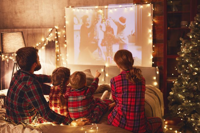 family watching christmas movies on projector at home