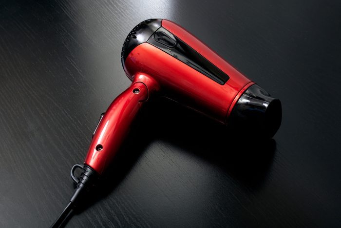 Red hairdryer on a black wooden table