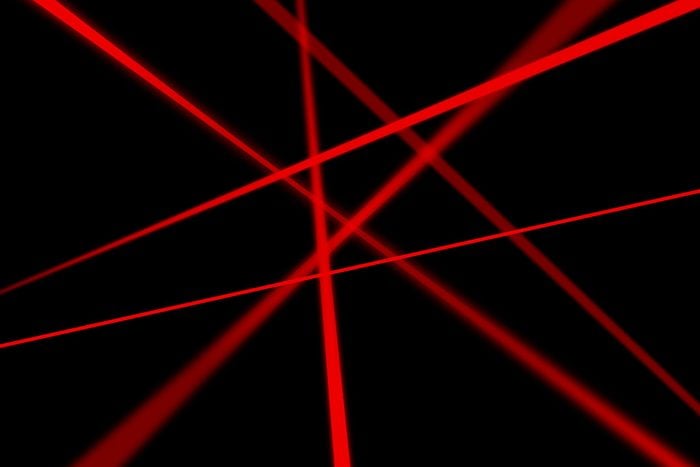 Red laser beams on black background