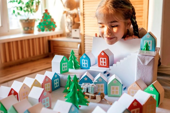 Origami Advent Calendar, Paper Craft. Girl Looking Upon Paper Houses With Number And Paper Tree