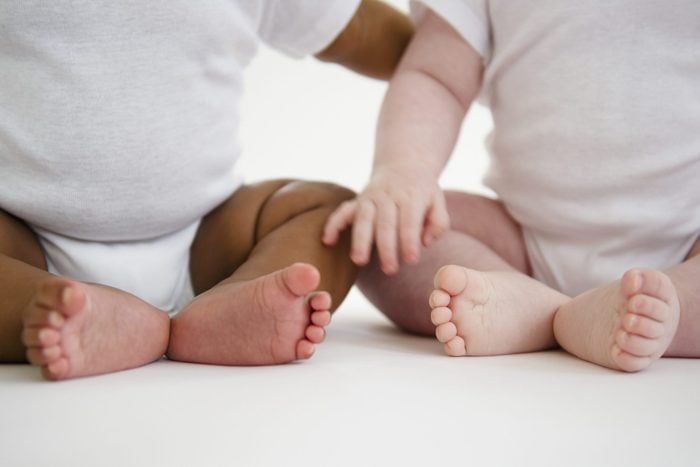 two babies sitting close up of their feet