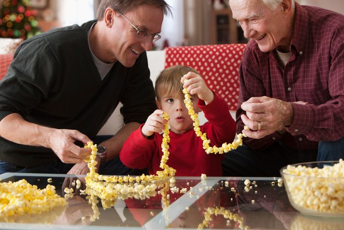 father and son making popcorn garland