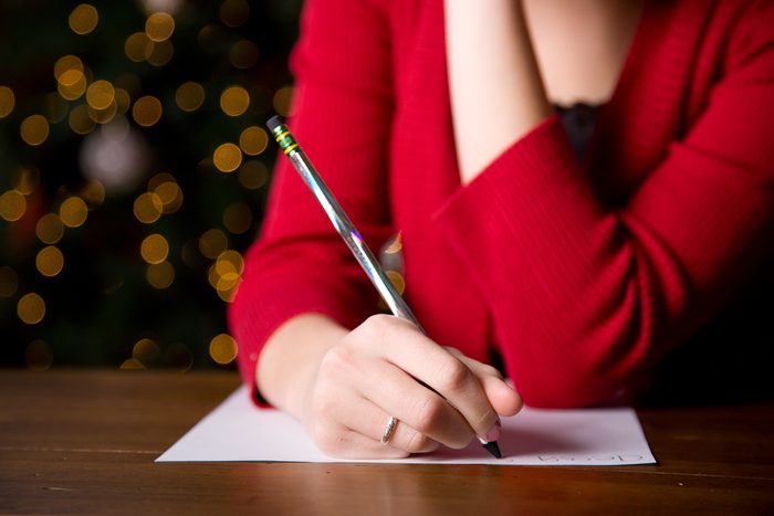writing a christmas letter by the christmas tree
