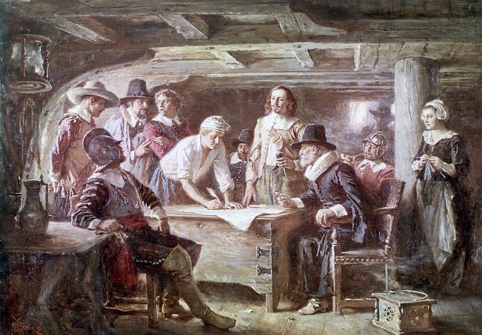 The signing of the Mayflower Compact by passengers on board the Mayflower in November 1620. The sitters include John Carver, John Alden, Myles Standish, John Howland and William Bradford. Painting by Jean Leon Gerome Ferris, 1899.