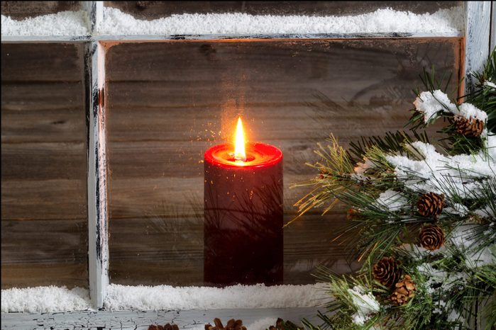Tea Light Candle Seen Through Glass Window During Winter