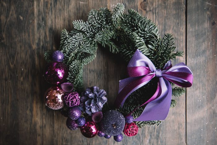 Beautiful festive winter hand made wreath on the rustic wooden table background, top view